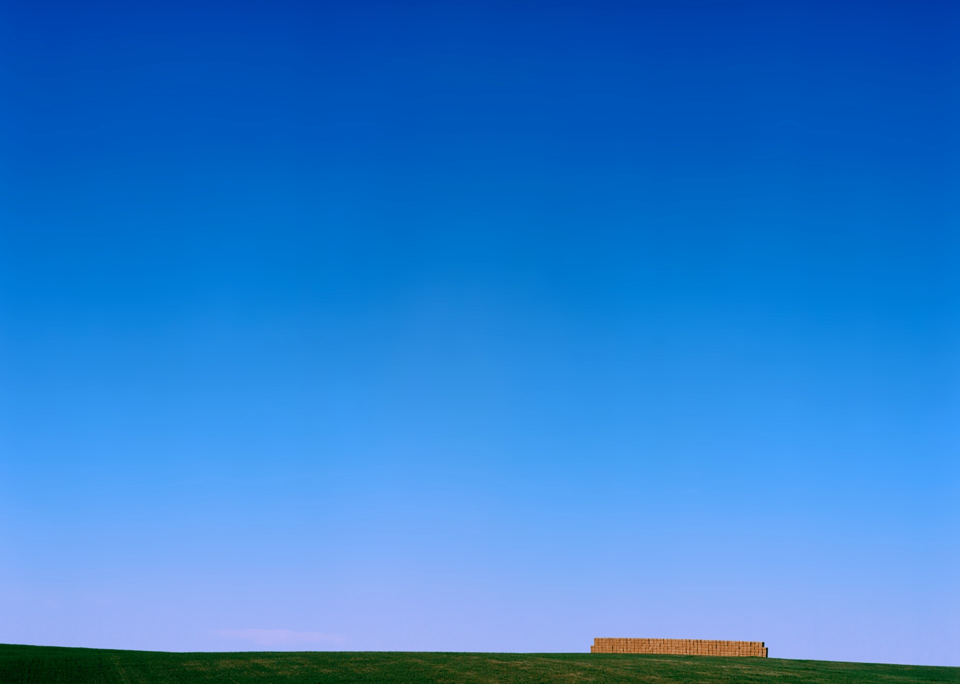 A roadside scene in the farmlands of Drummond, Idaho. Most apparent in the photo is the gradient between a deep blue and sky blue at the horizon